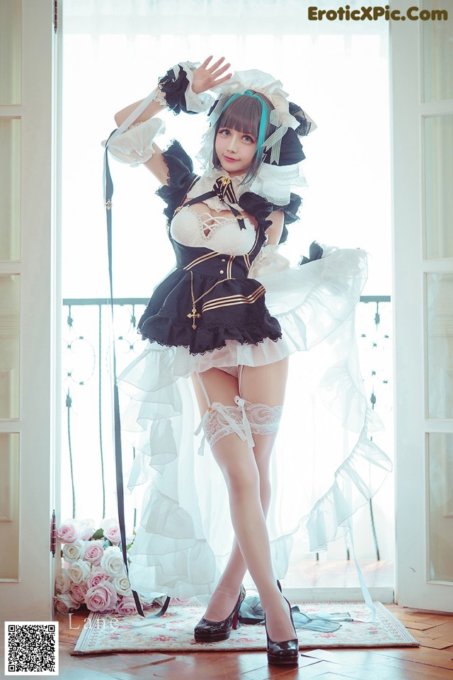 A woman in a maid outfit posing for a picture.