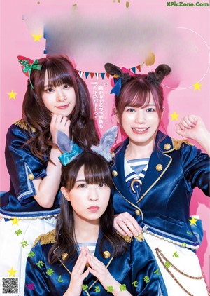 A group of three young women posing in front of colorful curtains.