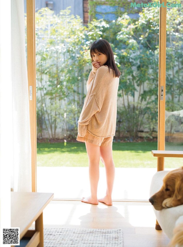 A woman standing in front of a sliding glass door.