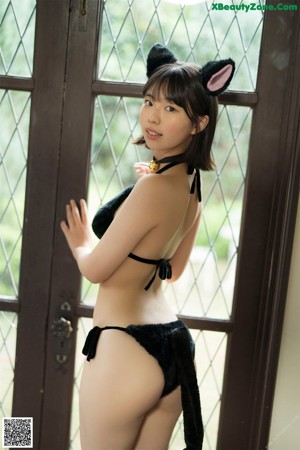 A woman in a black bikini with cat ears on her head.