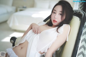 A woman sitting on top of a white chair.