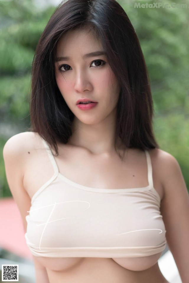 A woman in a white bra top posing for a picture.