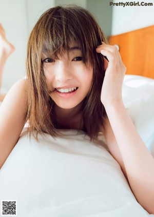 A woman in a white dress posing for a magazine cover.