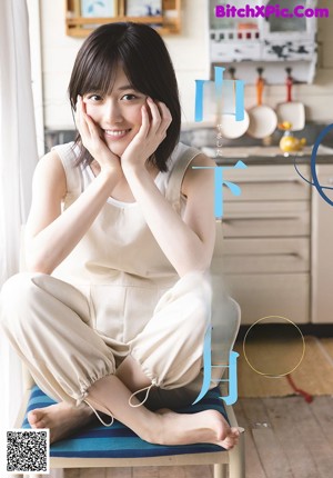 A woman holding a bowl of ice cream in a kitchen.