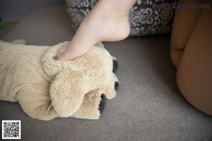 A woman is sitting on a couch with her legs crossed.
