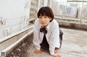 A young girl standing in front of a rack of clothes.