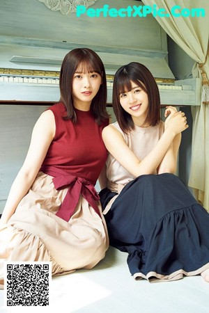 Two young women sitting on a porch holding guitars.