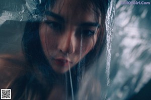 A naked woman wrapped in plastic is posing for the camera.
