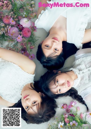 A group of young women sitting on top of a bed.