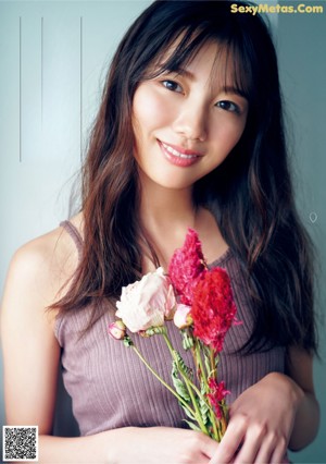 A woman in a white dress holding a bouquet of flowers.