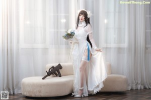 A woman in a wedding dress sitting on a couch.
