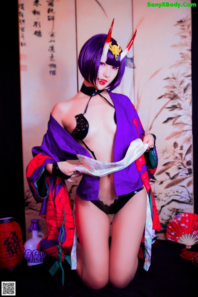 A woman in a purple kimono is posing for a picture.