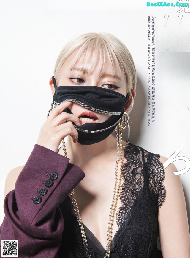 a woman wearing a black mask and a purple jacket