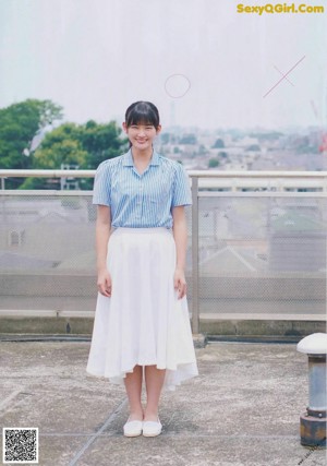 A woman standing on top of a roof next to a bench.