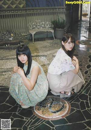 A couple of women standing on top of a tiled floor.