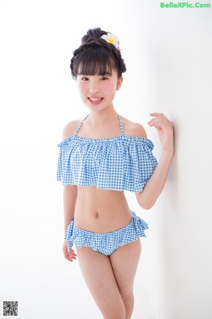 A woman in a blue and white gingham bikini posing for a picture.