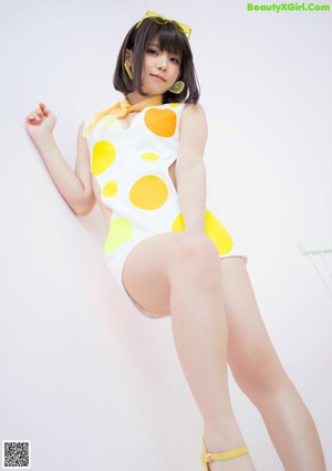 A woman in a yellow and white outfit is posing for a picture.