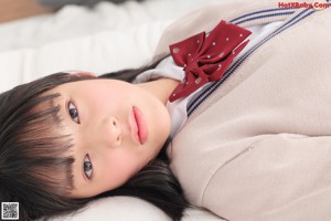 A woman with long black hair wearing a red bow tie.