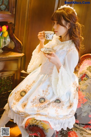 A woman in a blue and white dress sitting on a staircase.