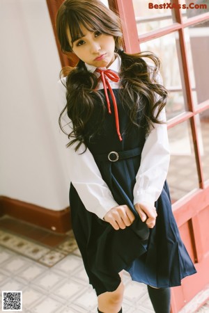 A young woman in a school uniform posing for a picture.