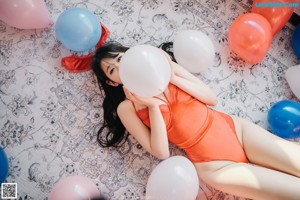 A woman in a bunny costume laying on a bed.