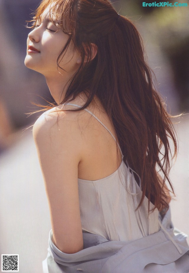 A woman with long brown hair is posing for a magazine.