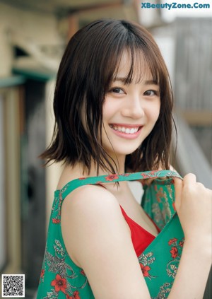 A woman in a green and red dress posing for a picture.