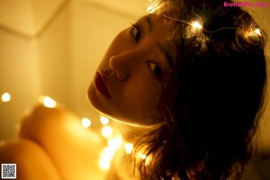 A naked woman with a string of lights around her body.