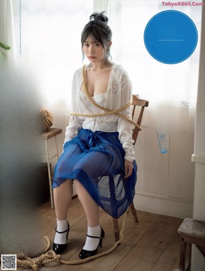 A woman wearing a blue bra and panties laying on a bed.