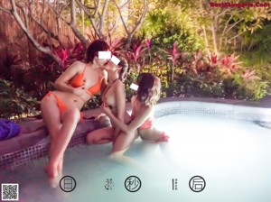 A group of three women sitting in a swimming pool.