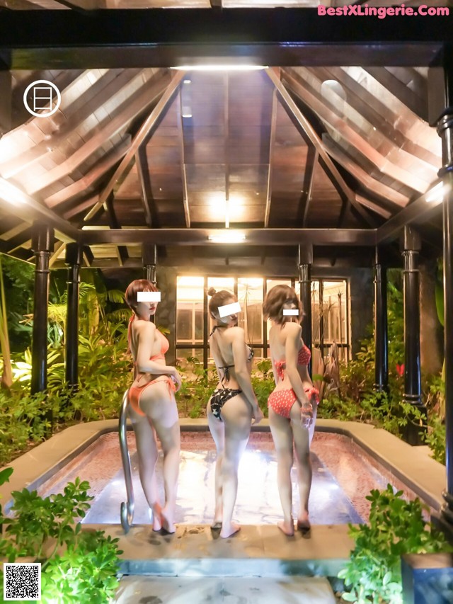 A group of women standing next to each other near a pool.